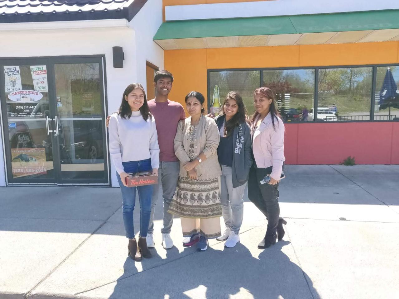 Tiffany and Aravind with family outside a restaurant